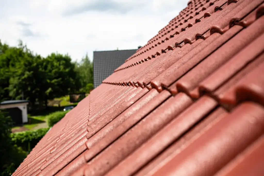 Frisch sanierte und ziegelrot beschichtete Dachziegel eines Wohnhauses im Raum Bautzen, professionell umgesetzt von Malermeister Poitz.
