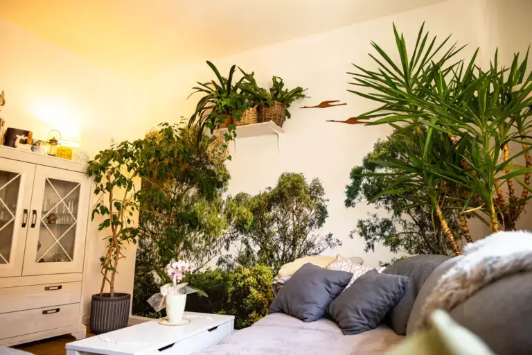 Modern renoviertes Wohnzimmer mit einer realistischen Fototapete im Wald-Design hinter dem Sofa und verlegtem Parkettboden in Wilder Eiche.