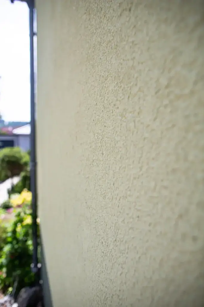 Detailansicht der Hausecke mit dem sauber abgegrenzten, grau-grünen Fassadensockel, ausgeführt von Malermeister Poitz.