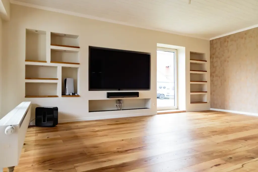 Wohnzimmer mit TV-Wand, Regal-Nischen und Blick nach draußen