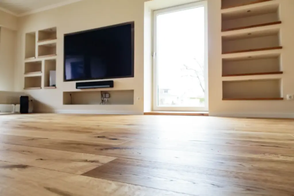 Blick durch die Zimmerflucht auf das Wohnzimmer mit TV-Wand