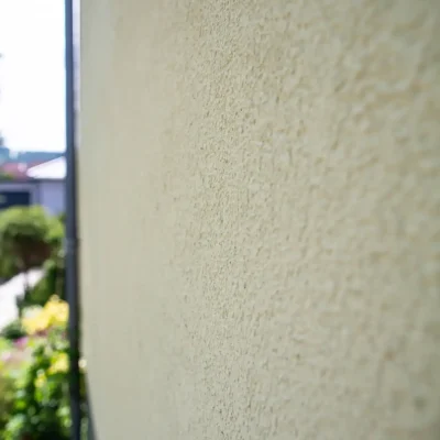 Detailansicht der Hausecke mit dem sauber abgegrenzten, grau-grünen Fassadensockel, ausgeführt von Malermeister Poitz.