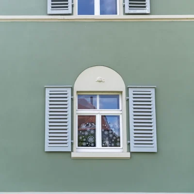 Blick von unten auf den Eingangsbereich der Büro-Villa mit stilvoller Außenleuchte und historischer Architektur.