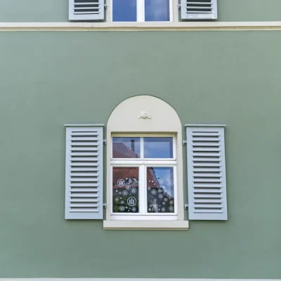 Blick von unten auf den Eingangsbereich der Büro-Villa mit stilvoller Außenleuchte und historischer Architektur.
